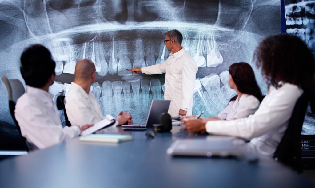 dentist or practice owner leading a meeting or speaking with the team.